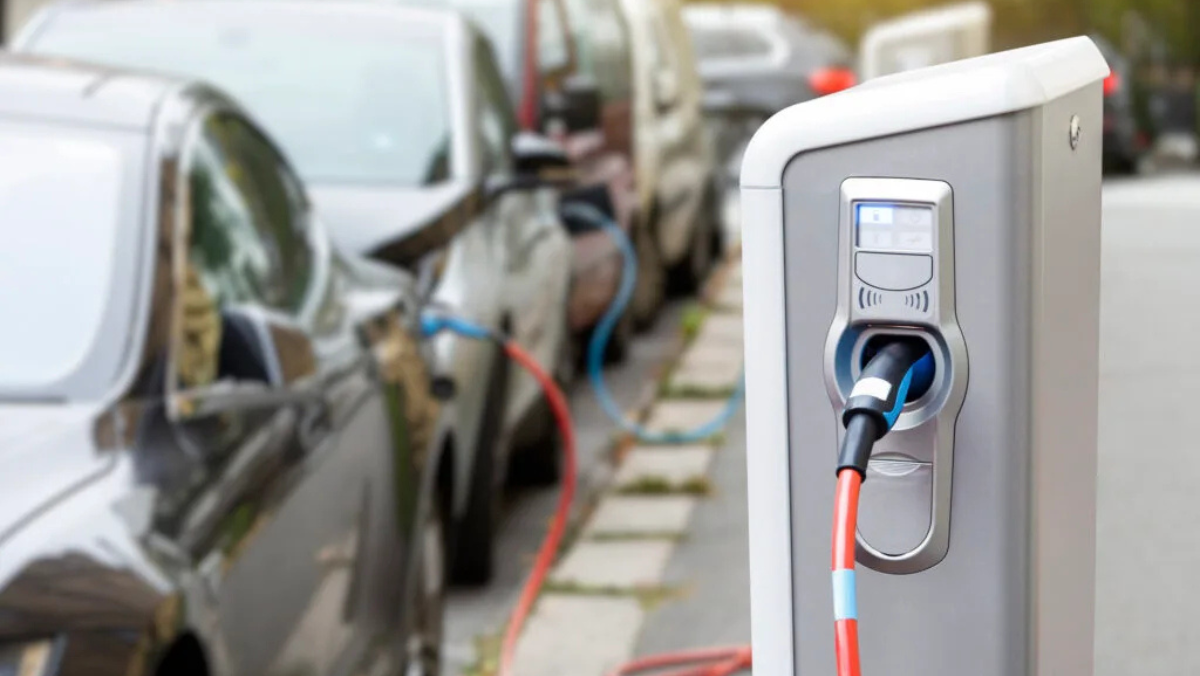 Electric vehicles plugged into a curbside charging station for power