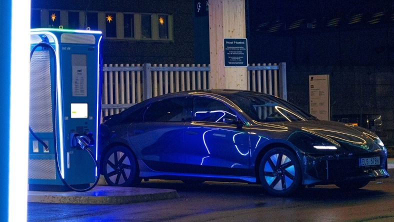 Electric vehicle connected to bidirectional charging station at night